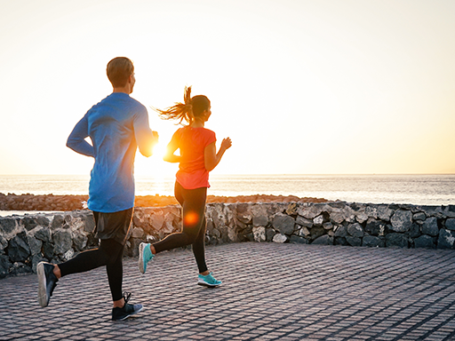 Two individuals jogging on the beach in California.